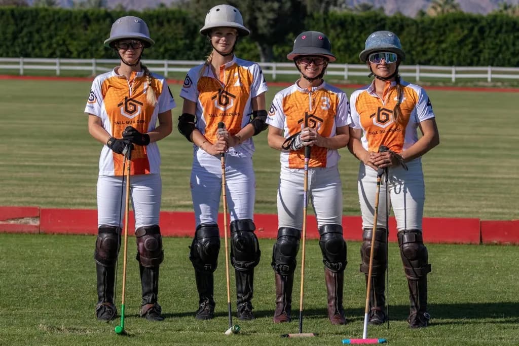 Four Apollo Team polo players in Tall Builders jerseys standing on the field with their mallets
